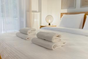 twee opvouwbare handdoeken bovenop een bed bij Daphnes Home Chalkida Central in Chalkida