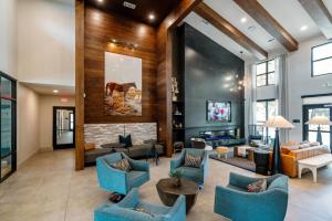 een woonkamer met blauwe stoelen en een open haard bij Landing Apartments - Leander in Leander