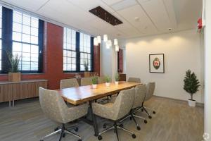 an office meeting room with a wooden table and chairs at Landing Apartment - New Haven in New Haven