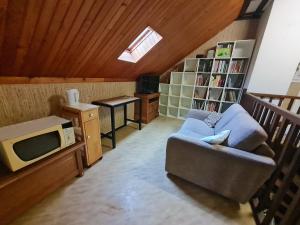 a living room with a couch and a tv at Maison d'Hôtes de Belleville in Belleville
