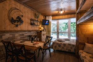 een eetkamer met een tafel en een bed bij Les Champis in La Bresse