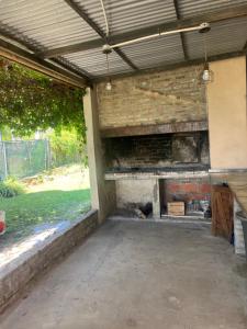 an outdoor patio with a fireplace in a building at Quinta Atardeceres in Aldea Brasilera