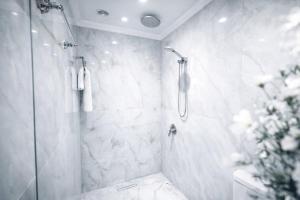 a white bathroom with a shower and a toilet at Yerevan In Boutique Hotel in Yerevan