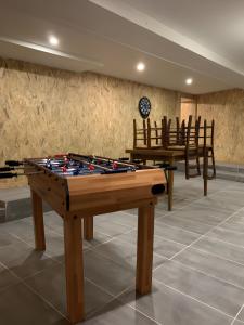 een tafeltennistafel in een kamer met stoelen bij Gîte Un Toit Pour Vous in Les Épesses