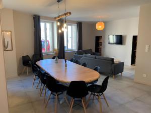 een woonkamer met een houten tafel en stoelen bij Gîte Un Toit Pour Vous in Les Épesses +6 foto's