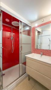 een rode badkamer met een wastafel en een douche bij Studio indépendant en villa Calme, Jardins et Piscine à 5 min de la Mer in Nice