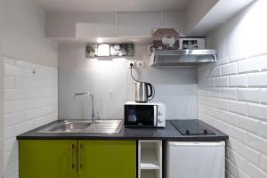 een kleine keuken met een spoelbak en een magnetron bij Studio indépendant en villa Calme, Jardins et Piscine à 5 min de la Mer in Nice