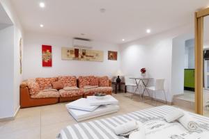 een woonkamer met een bank en een tafel bij Studio indépendant en villa Calme, Jardins et Piscine à 5 min de la Mer in Nice