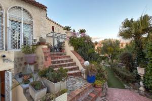 een tuin met trappen en potplanten en een gebouw bij Studio indépendant en villa Calme, Jardins et Piscine à 5 min de la Mer in Nice