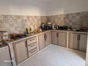 een keuken met witte kasten en een magnetron bij bedroom double bed private bathroom in Agadir