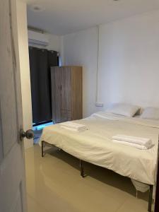 a bedroom with a bed with two towels on it at CİMELi Guest House in Patong Beach