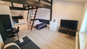 un soggiorno con letto a soppalco e TV di Dream Apartments 3B KLIMATYZACJA a Oświęcim