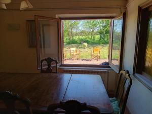 ein Tisch und Stühle in einem Zimmer mit Fenster in der Unterkunft FRANCIAC Casanova in Franciach