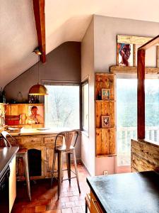 eine Küche mit einer Theke und Stühlen in einem Zimmer in der Unterkunft Maison à 5mn de Honfleur in Fourneville