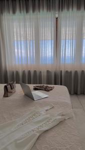 een wit bed met een laptop erop bij MEDITERRANEAN SEASONS, VILLA MEDITERRANEA Taormina, Private Pool & Sea View in Taormina