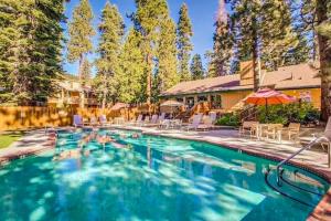 a swimming pool with chairs and an umbrella at Cozy Kings Run Condo in Kingswood Estates