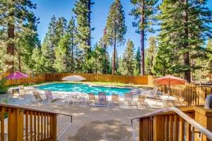 a swimming pool with chairs and umbrellas in a yard at Cozy Kings Run Condo in Kingswood Estates