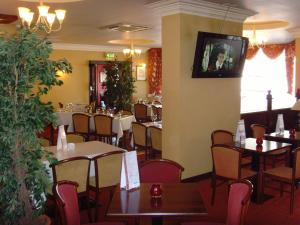 a dining room with tables and chairs in a restaurant at Villa Hotel in Hamilton