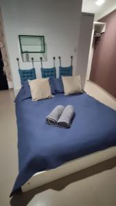 un grande letto blu con due cuscini sopra di Flat mobiliado e bem localizado a Recife