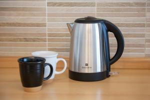 a coffee pot and two cups on a table at ArtStay Apt near Rho Fiera, Pool, Parking in Settimo Milanese