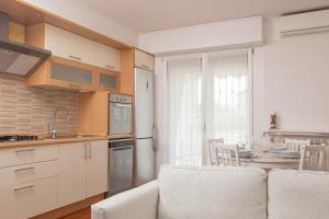 a kitchen with white cabinets and a table and a kitchen with a couch at ArtStay Apt near Rho Fiera, Pool, Parking in Settimo Milanese