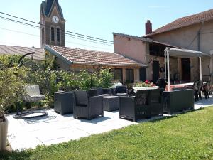 une terrasse avec des chaises, une table et une église dans l'établissement O p'tit nid à bulles, à Létricourt 4 autres photos
