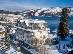 a building with a canadian flag on top of it at Belvédère Strandhotel in Spiez
