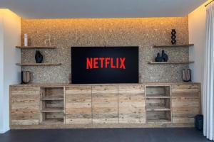 a television on top of a wooden entertainment center at A&Y Signature Lodge St Moritz Pontresina Spa in Pontresina