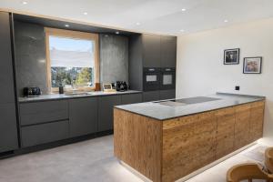 a kitchen with a wooden island in the middle at A&Y Signature Lodge St Moritz Pontresina Spa in Pontresina