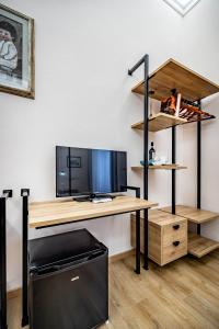 a desk with a tv and a computer on it at Five Suites Mantellate 9 in Florence