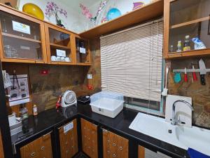 een keuken met een spoelbak en een aanrechtblad bij KARN E2 House Khaoyai in Mu Si