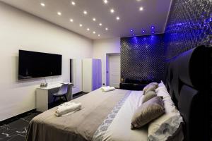 ein Schlafzimmer mit einem großen Bett, einem Schreibtisch und einem Fernseher in der Unterkunft Scio' Scio' in Neapel