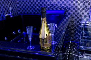 Eine Flasche Champagner und drei Weingläser stehen auf einer Theke. in der Unterkunft Scio' Scio' in Neapel + 95 Fotos