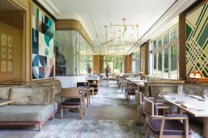a dining room with tables and chairs and windows at Brenners Park Hotel & Spa, Oetker Hotels in Baden-Baden