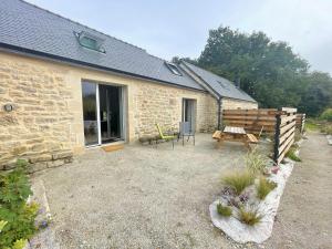 a stone cottage with a picnic table and a bench at Kervel et Lokorn in Locronan