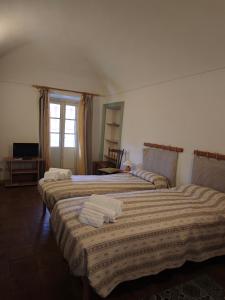 a hotel room with three beds and a window at Cascina Montalbano in Rosignano Monferrato