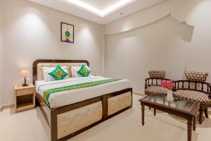 une chambre avec un lit, une table et une chaise dans l'établissement Treebo Paras International, à New Delhi