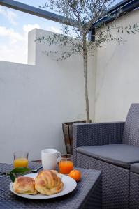 ein Teller mit Croissants und Orangen auf einem Tisch in der Unterkunft Appartement RoofTop - Montélimar in Montélimar