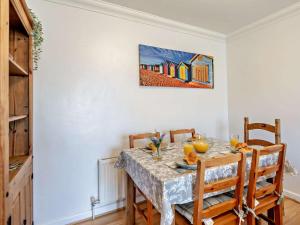 een eettafel met stoelen en een schilderij aan de muur bij 2 Bed in Kings Lynn oc-chln8 in Heacham