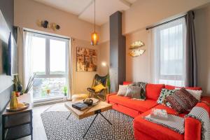 un soggiorno con un divano rosso e un tavolo di Buchanan 401 - Midtown Condo Luxe and gym a Montréal