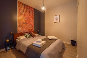 una camera da letto con un letto e un muro di mattoni di Buchanan 401 - Midtown Condo Luxe and gym a Montréal