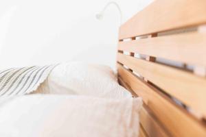 een bed met een houten hoofdeinde bij Ferienwohnung Am Alpenblick in Lindau