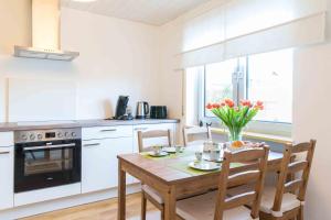 een keuken met een houten tafel en een eetkamer bij Ferienwohnung Am Alpenblick in Lindau