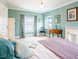 een slaapkamer met een bed, een bureau en een raam bij 3 Bed in Narberth 79443 in Narberth