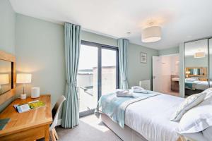 een slaapkamer met een bed, een bureau en een raam bij 2 Bed in Woolacombe oc-c27395 in Woolacombe +23 foto's