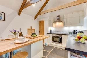 a kitchen with white cabinets and a counter top at 1 Bed in Duloe oc-l30057 in Duloe +8 photos