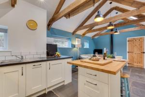 a kitchen with white cabinets and blue walls at 1 Bed in Duloe oc-l30057 in Duloe