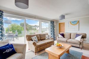 a living room with two couches and a table at 3 Bed in Fowey oc-tidewa in Fowey