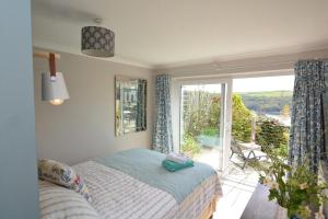 a bedroom with a bed and a large window at 3 Bed in Fowey oc-tidewa in Fowey
