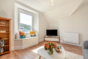 ein Wohnzimmer mit Tisch und Fernseher in der Unterkunft 1 Bed in Looe oc-s29019 in Looe